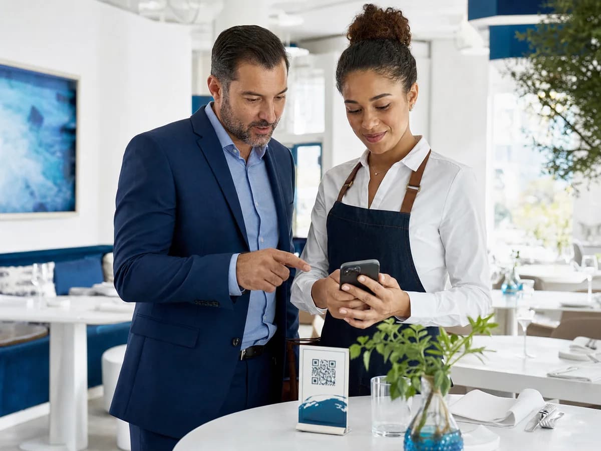 Restaurant team reviewing a digital menu opened from a QR table card